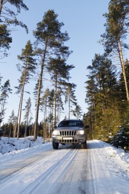 Suv, car, driving on snowy country road clipart