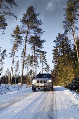 Suv, car, driving on snowy country road clipart