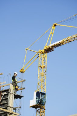 Crane operator inside building-site clipart