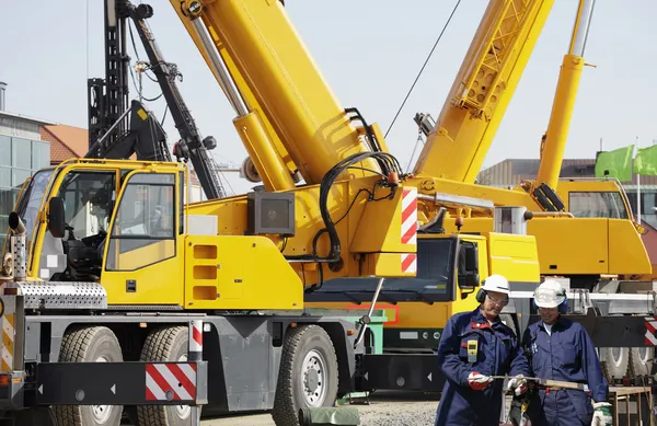 Giant mobile cranes and site-workers — Stock Photo, Image