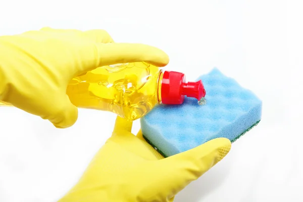 Manos en guantes de goma con una botella de detergente y esponja — Foto de Stock