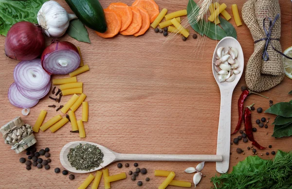 Frame made of spices and vegetables on a wooden table. — Stock Photo, Image