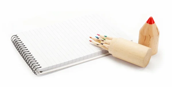 Lápices de colores en una caja de madera y un cuaderno en blanco . — Foto de Stock