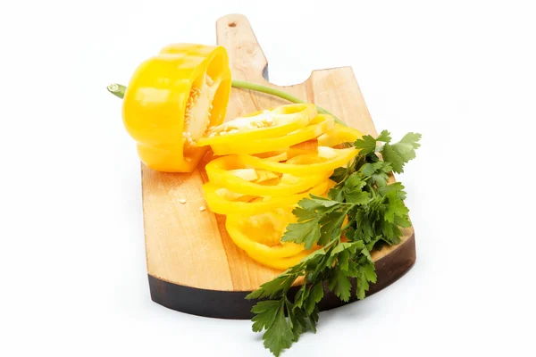 Pimenta amarela e salsa em uma placa de madeira isolada . — Fotografia de Stock