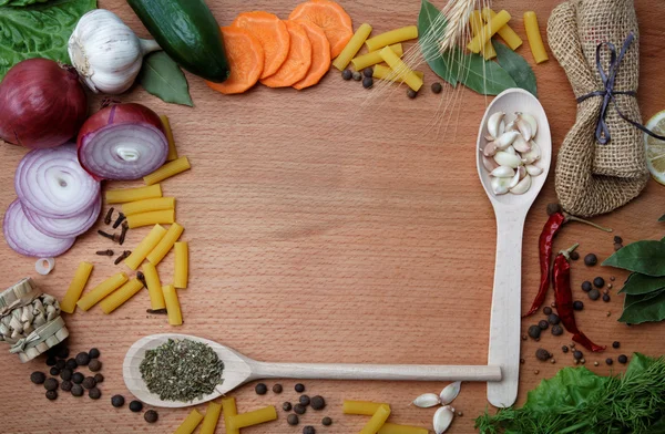 Frame made of spices and vegetables on a wooden table. — Stock Photo, Image