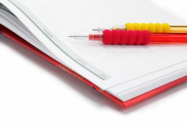 Два автоматичні олівці в щоденнику на білому тлі . — стокове фото
