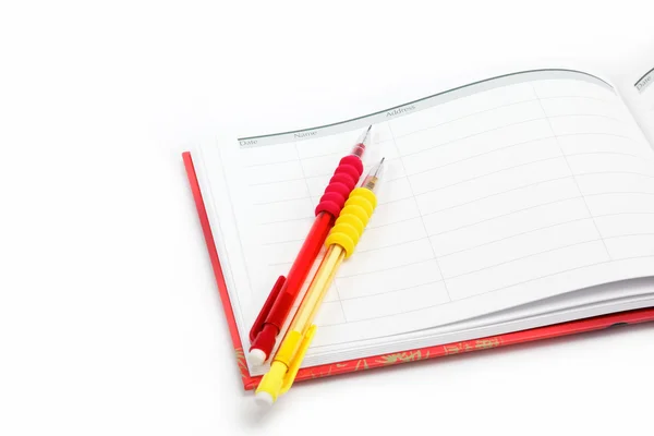 Două creioane automate în jurnal pe un fundal alb . — Fotografie, imagine de stoc