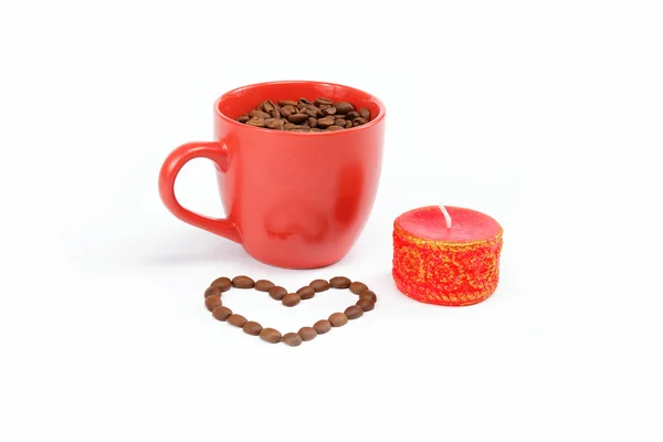 Koffie bonen in de cup en een kaars op een witte achtergrond. — Stockfoto