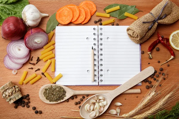 Cuaderno para recetas y especias sobre tabla de madera — Foto de Stock