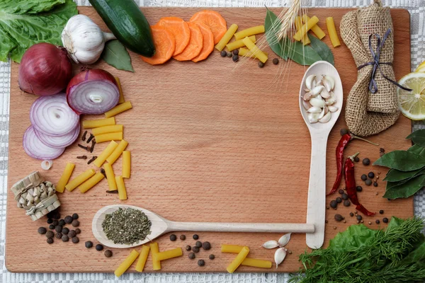 stock image Frame made of spices and vegetables on a wooden table.