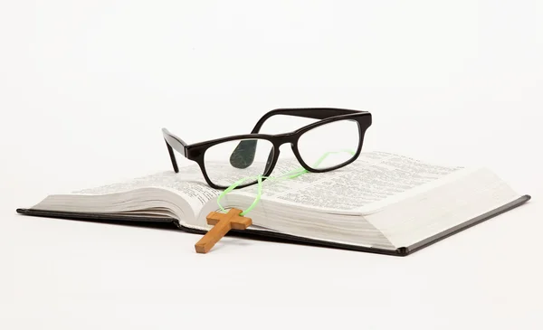 Открыть книгу / Библия и очки на белом фоне — стоковое фото
