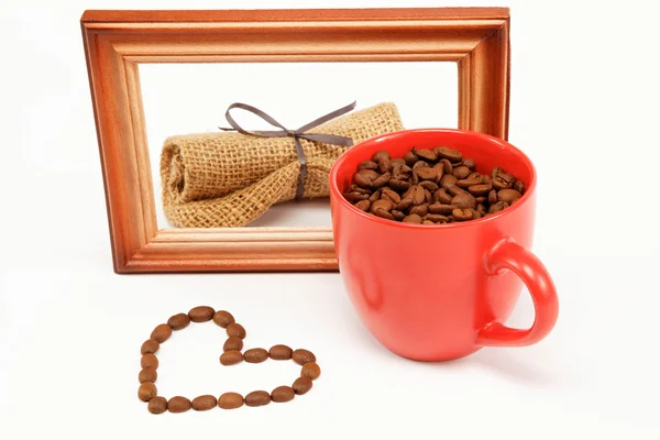 Le cœur des grains de café autour d'une tasse de café et d'un boisé — Photo