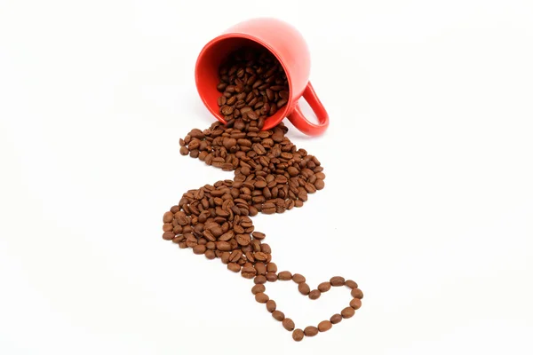 Herzstück der Kaffeebohnen aus umgestürzter Tasse. — Stockfoto