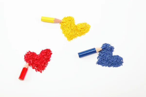Lápices de color y tres corazones aislados sobre fondo blanco . — Foto de Stock