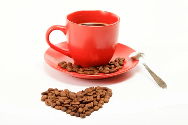 Сердце сделано в том числе из кофейных зерен вокруг чашки кофе на w — стоковое фото