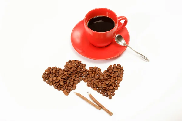 İki kalp yapılan?? bir fincan kahve o etrafında kahve çekirdekleri — Stok fotoğraf