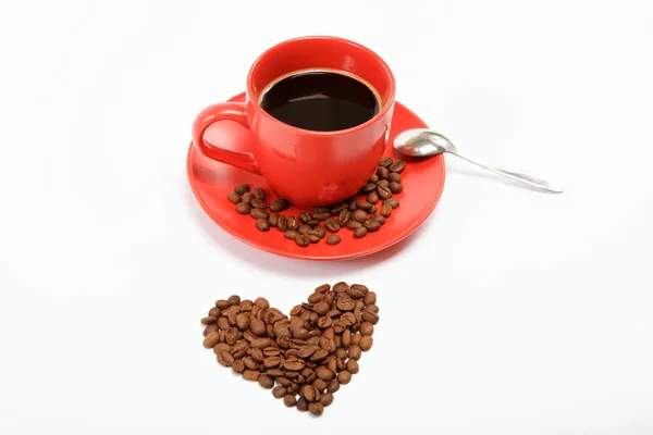 Coração feito de grãos de café em torno de uma xícara de café em um w — Fotografia de Stock