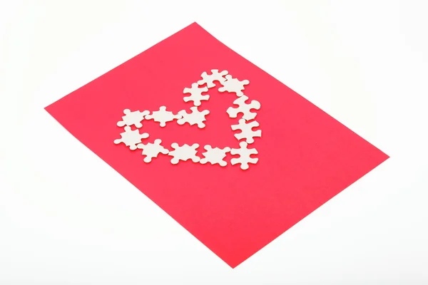 Puzzle a forma di cuore su sfondo rosso . — Foto Stock