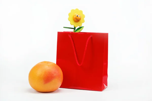 Червона подарункова сумка та цитрусові на білому тлі . — стокове фото