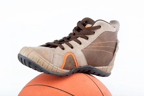 Nové sportovní boty s míčem na bílém pozadí. — Stock fotografie