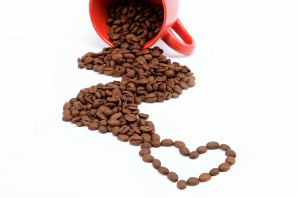 Herzstück der Kaffeebohnen aus umgestürzter Tasse. — Stockfoto