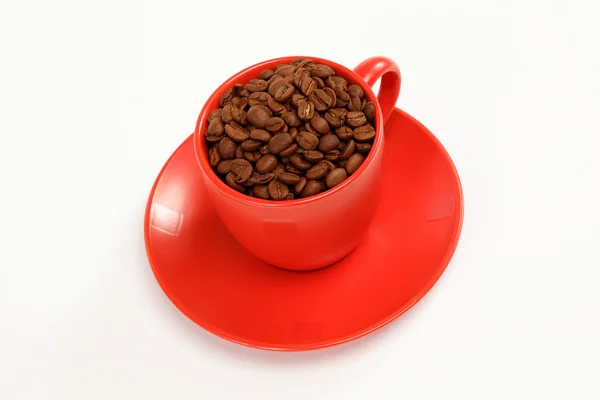 Taza con granos de café en un plato sobre un fondo blanco . — Foto de Stock