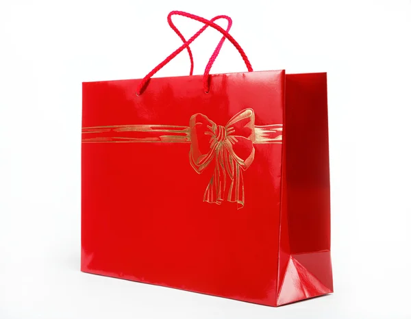 Piros ajándék táska női kezek-ra egy fehér háttér. — Stock Fotó