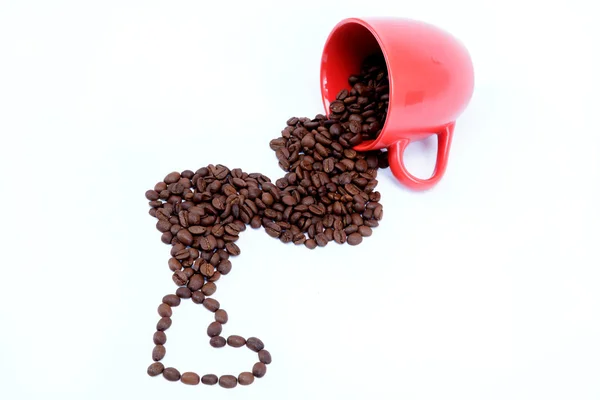 Srdce kávová zrna z převržené pohár. — Stock fotografie