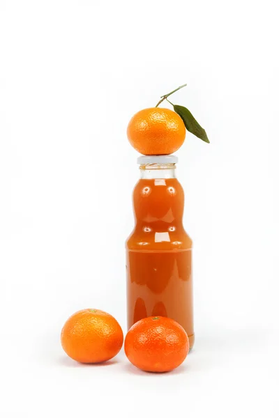 Juice i ett glas flaska och tropiska frukter på en vit bak — Stockfoto