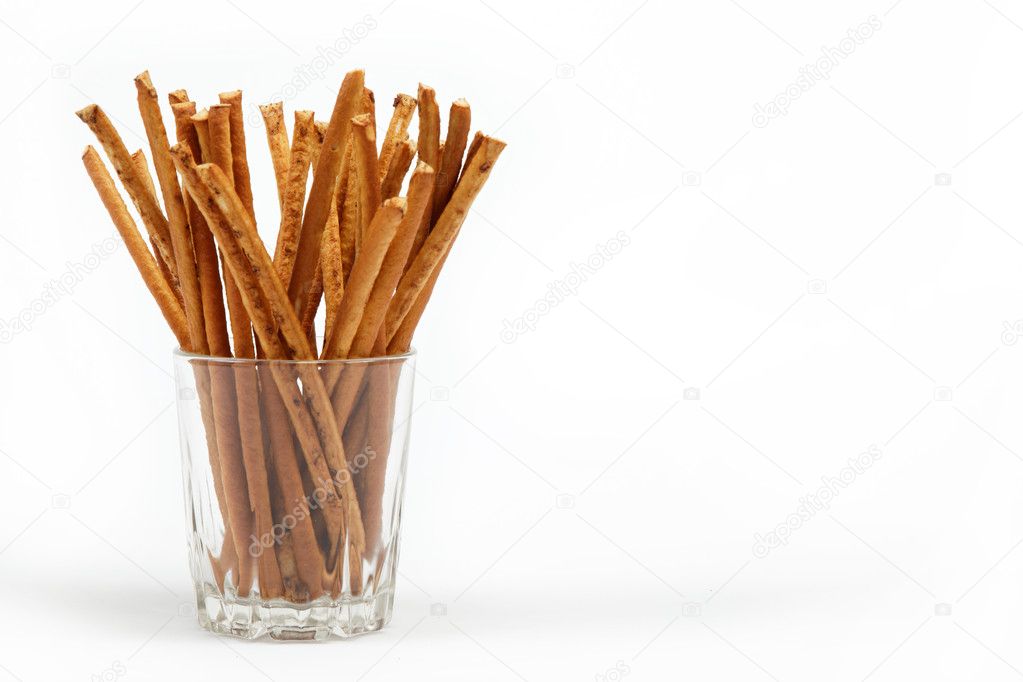 Crispy bread straw in a glass on a white background.