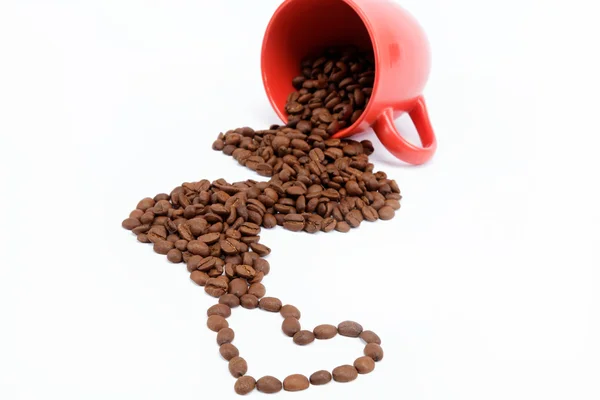 Corazón de los granos de café de una taza volcada . —  Fotos de Stock