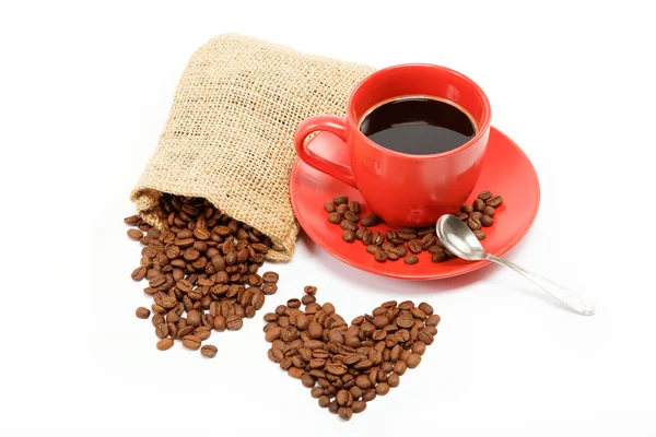 Corazones hechos de granos de café alrededor de una taza de café en un —  Fotos de Stock