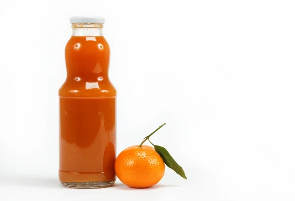 Jugo en una botella de vidrio y frutas tropicales sobre un fondo blanco — Foto de Stock