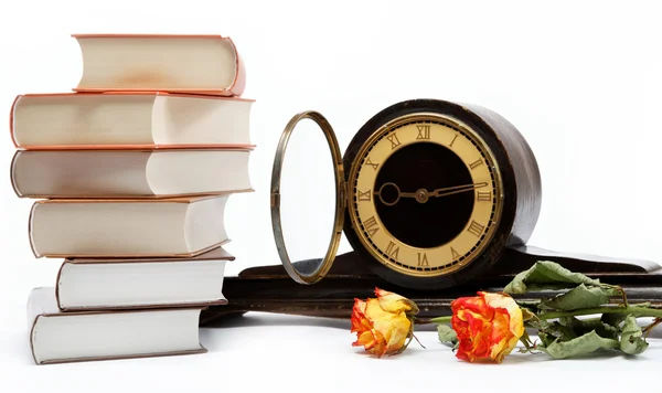 Stoh knih a starožitné hodiny na bílém pozadí. — Stock fotografie
