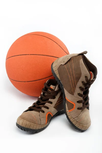 Нове спортивне взуття з м'ячем на білому тлі . — стокове фото