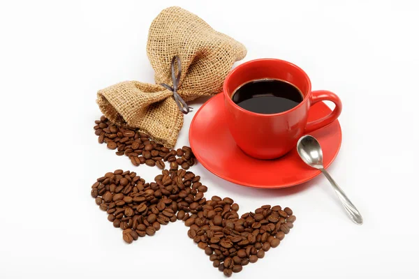 Heart made ​​from coffee beans around a cup of coffee on a w — Stock Photo, Image