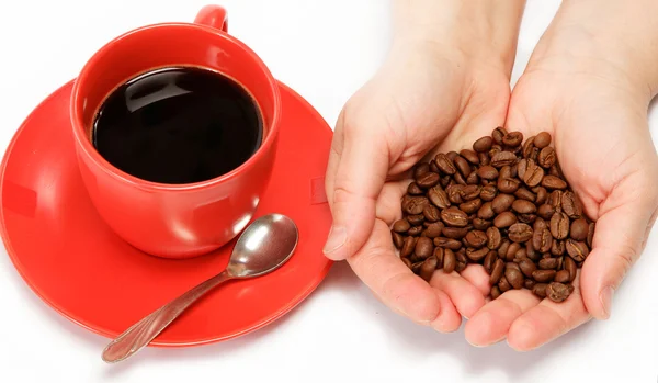 Corazón en mano hecho de granos de café alrededor de una taza de café —  Fotos de Stock