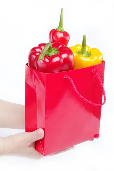 Свежие овощи. Красный подарочный пакет в женских руках на белой б — стоковое фото