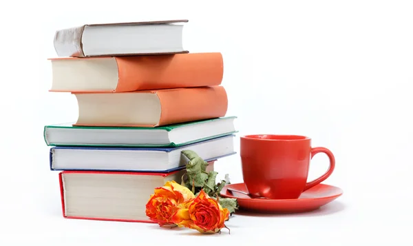 Una pila di libri e una tazza di caffè in un piattino su un retro bianco — Foto Stock