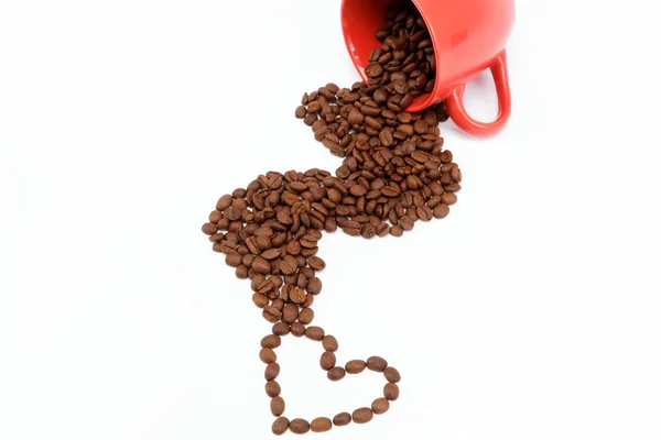 Srdce kávová zrna z převržené pohár. — Stock fotografie