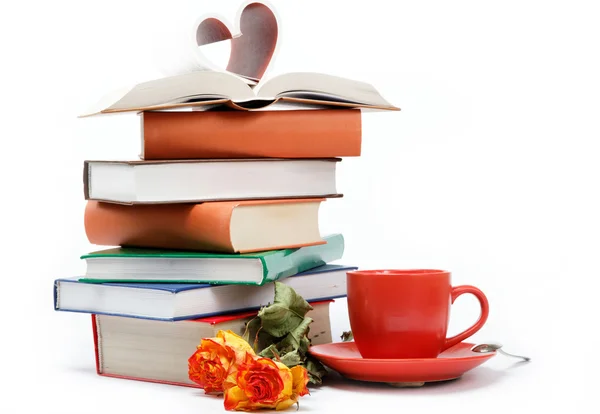 En trave böcker och en kopp kaffe i ett fat på en vit baksida — Stockfoto