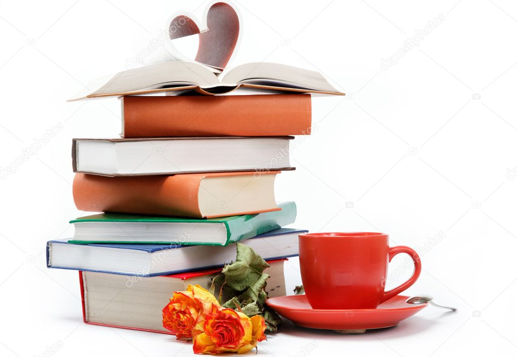 A stack of books and a cup of coffee in a saucer on a white back