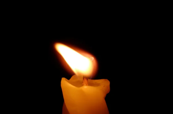Gelbe Kerze auf schwarzem Hintergrund — Stockfoto