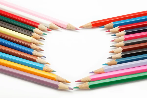 Ołówki kolorowe kredki składa się w formie serca — Zdjęcie stockowe