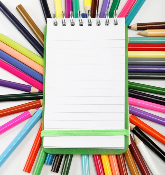 Bloc-notes sur fond de crayons de couleur . — Photo