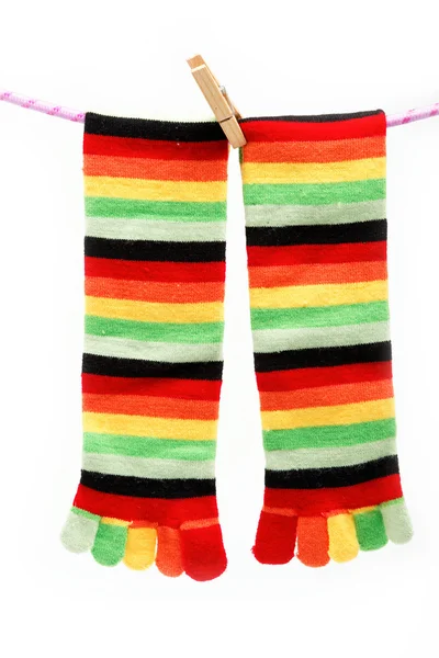 Meias divertidas coloridas anexado clothespin pendurado em uma corda . — Fotografia de Stock