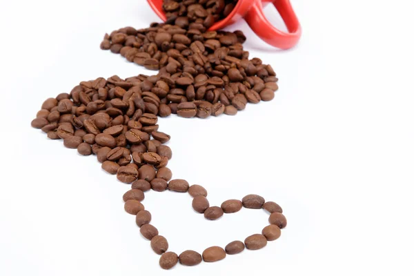 Kalp devrilmiş bir fincan kahve çekirdekleri. — Stok fotoğraf