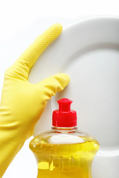 Hand in rubber glove with a plate and a bottle of detergent on a — Stock Photo, Image