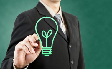 Businessman drawing light bulb green concept clipart