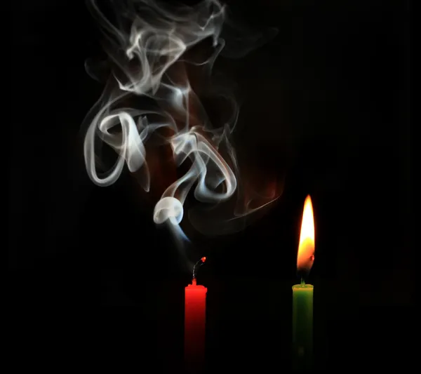 Spalování a světla zhášených svíček na černém pozadí — Stock fotografie